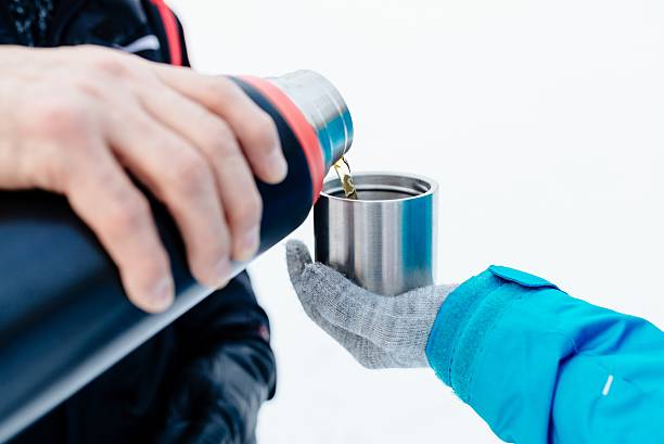 istock Man pouring hot tea from a thermos 637228144