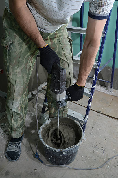 istock construction worker stirs the adhesive in the bucket building mi 637229250