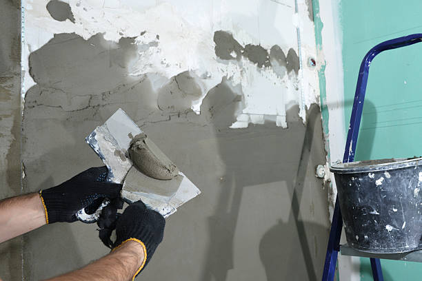 istock plasterer apply the plaster on the wall of a spatula 637229618