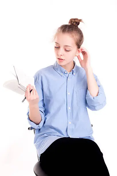 Photo of Caucasian pretty girl holding pad with pen thinking about writin