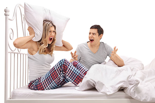 若いカップルはベッドで口論 - mattress bed cushion isolated ストックフォトと画像