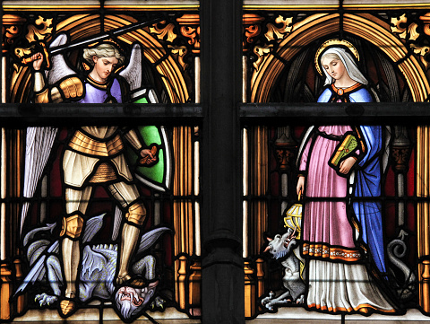 Brussels, Belgium - July 26, 2012: Stained glass window depicting the Patron Saints Gudula and Michael the Archangel of the Cathedral of Brussels, Belgium.