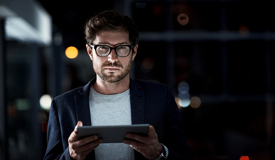 Shot of a young businessman using a digital tablet at work
