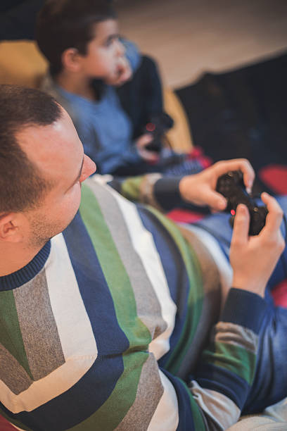 istock Father and son playing video games 637233110