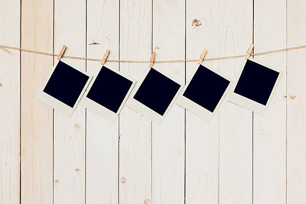 istock Five (5)blank photo frame hanging on white wood background 637233212