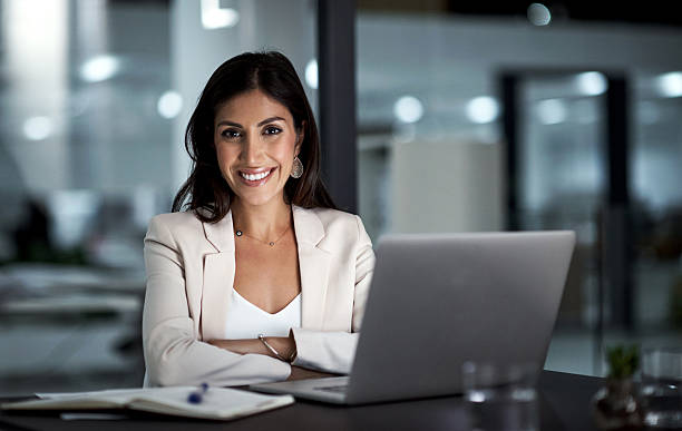 All set for a productive night ahead Portrait of a happy businesswoman working at her office desk middle eastern ethnicity photos stock pictures, royalty-free photos & images