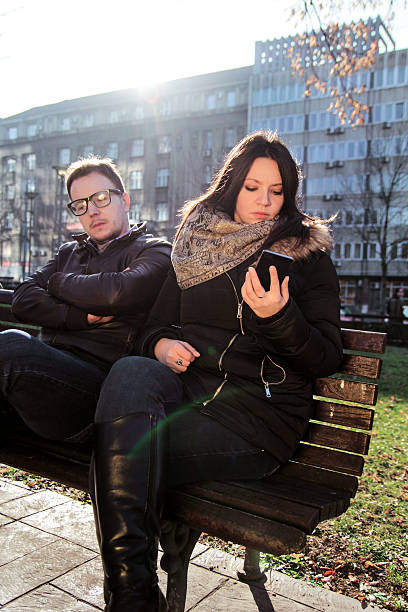 istock Boyfriend is bored and woman using a smartphone 637235042