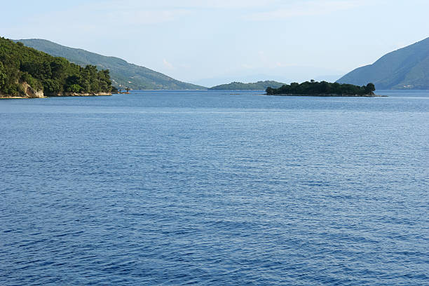 Panoramic view with blue sea, green island and mountains in Ionian sea, Greece.