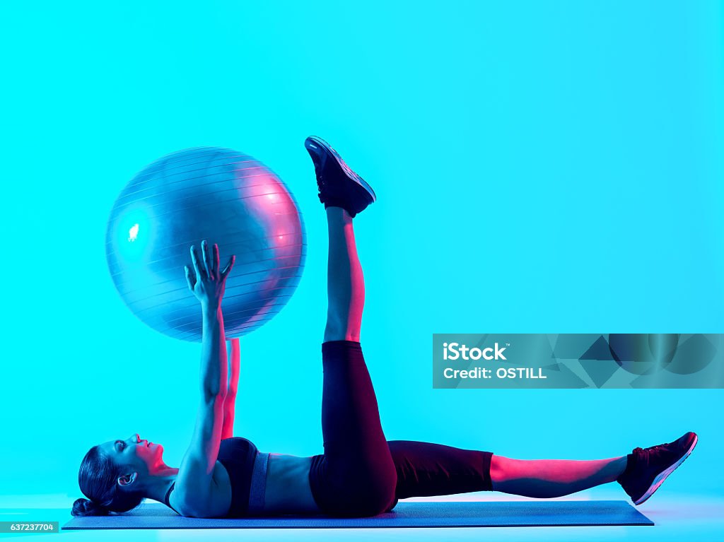 woman fitness pilates exercices isolated one mixed races woman exercsing fitness pilates exercices isolated on blue blackground Pilates Stock Photo