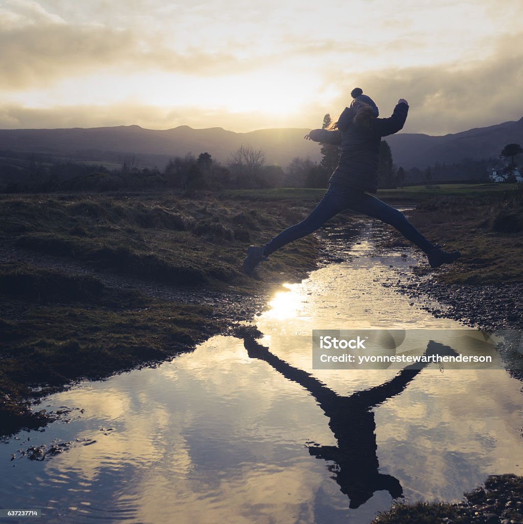 Girl Leaps Over Stream A Teen Jumps Over Water On A Nature Hike Jumping Stock Photo