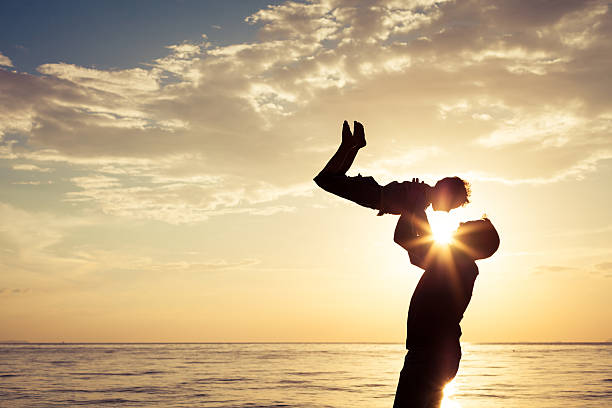 istock Father and son playing on the beach at the sunset 637238232