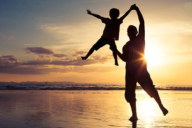 istock Father and son playing on the beach at the sunset 637238490