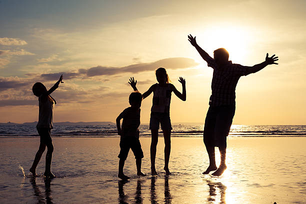 istock Father and children playing on the beach at the sunset 637240278