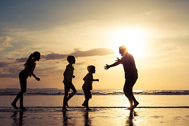 istock Father and children playing on the beach at the sunset 637240322