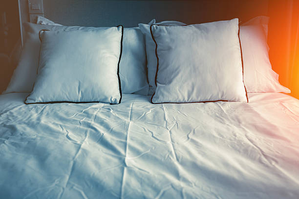 istock Bed maid-up with clean white pillows and bed sheets 637240784