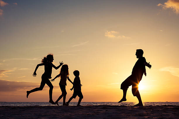 istock Father and children playing on the beach at the sunset 637240820