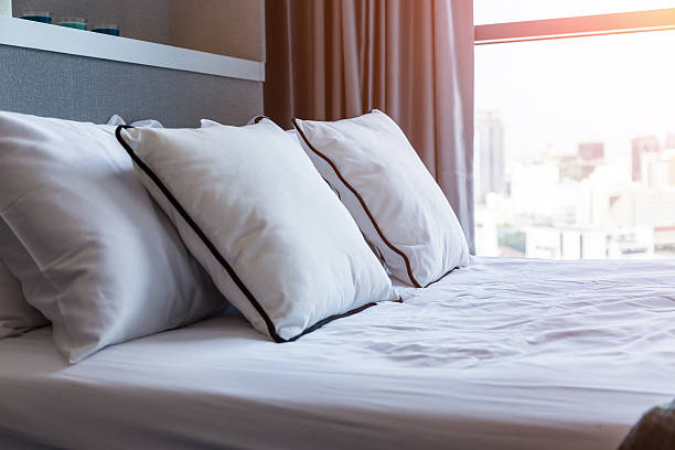 istock Bed maid-up with clean white pillows and bed sheets 637240830
