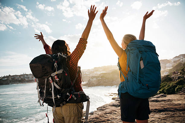 istock Two young women on vacation standing with arms spread open 637243080
