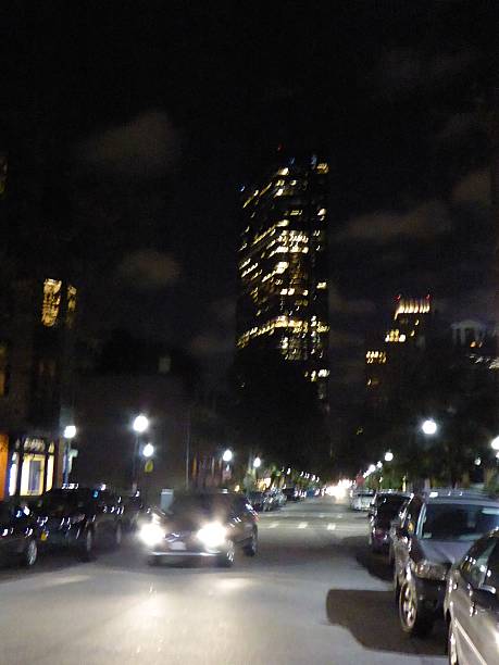 istock Car with headlights below the John Hancock building at night 637243092