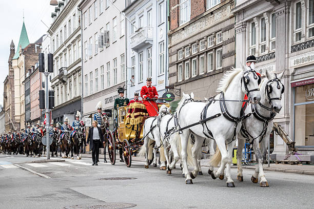Copenhagen, Denmark - January 04, 2017: Queen Margrethe in her 24-carat golden coach is escorted by the Guard Hussar Regiment on the way from Christiansborg Palace to Amalienborg Palacce