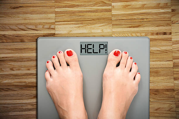 istock Diet concept with women’s feet on a scale, weighting herself 637243740