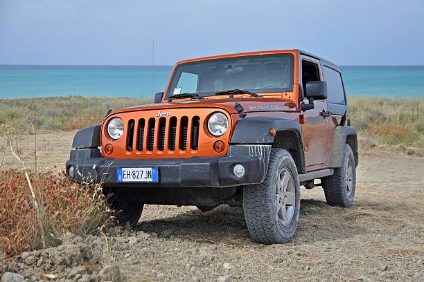 jeep wrangler rubicon на неоделеной дороге - jeep wrangler стоковые фото и изображения