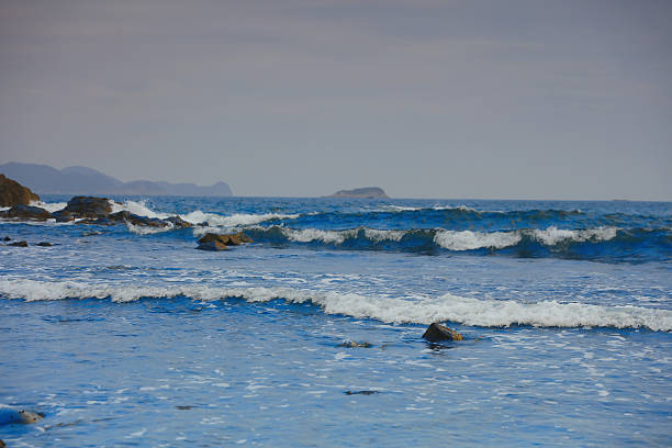 Waves at sea on dramatic sunset background. Waves at sea during storm and wind. Wave from the sea goes on land to the beach. Splashing Waves in ocean, background, texture. Wave at Rising Storm.