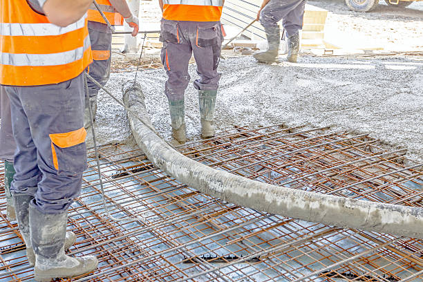 los trabajadores están esparciendo hormigón sobre un gran piso reforzado en el - wire mesh equipment gear working fotografías e imágenes de stock