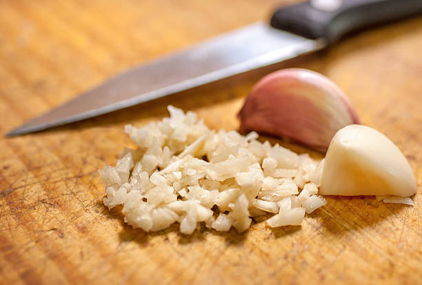 istock Finely cut garlic over wooden cutting board 637255532