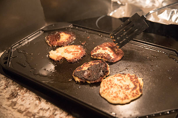 mésaventure de cuisine. crêpes de pommes de terre brûlées dans une plaque de cuisson - cooking fail photos et images de collection