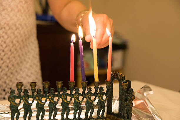 serie:anziana donna caucasica ebrea che accende candele in menorah - hanukkah menorah human hand lighting equipment foto e immagini stock