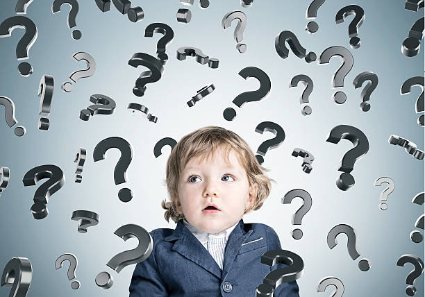 istock Baby boy and question marks on gray wall 637257602
