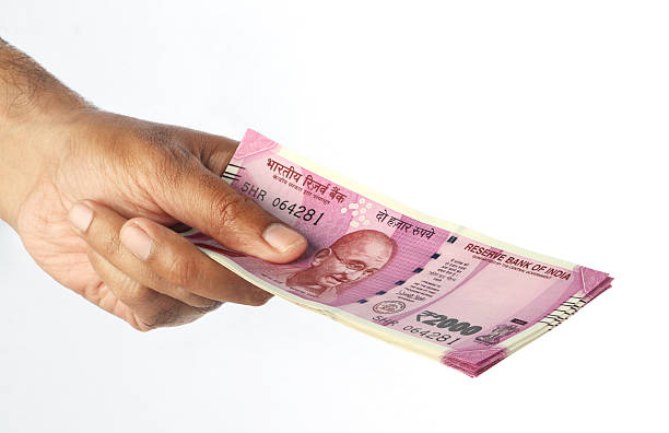 istock New Indian Rupee 2000 Currency Note in a Hand 637257728
