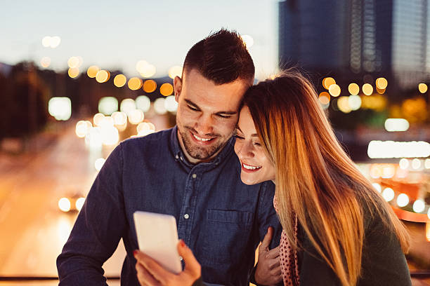 istock Couple sharing photos on smartphone 637259238