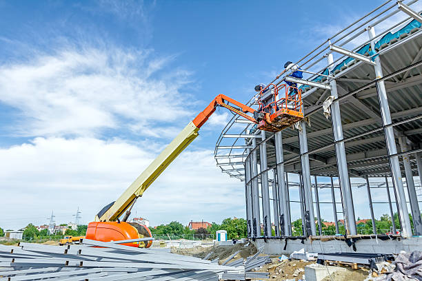 Height workers with help of cherry picker are working. High elevated cherry picker people are working at new assembled canopies on construction site. hoisting photos stock pictures, royalty-free photos & images