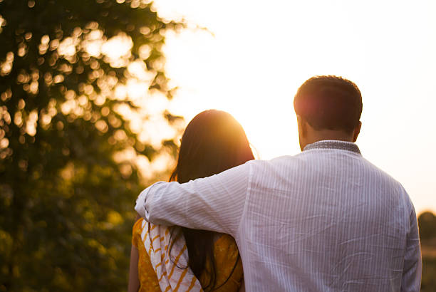 indisches paar umarmt während sonnenuntergang - stroking couple desire love stock-fotos und bilder