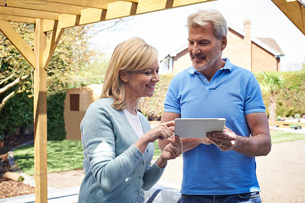 Mature Woman Looking At Design On Digital Tablet With Landscape