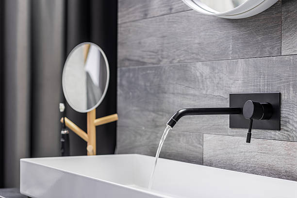 Washbasin with wall mounted tap Modern white washbasin with black tap mounted to wall mal stock pictures, royalty-free photos & images