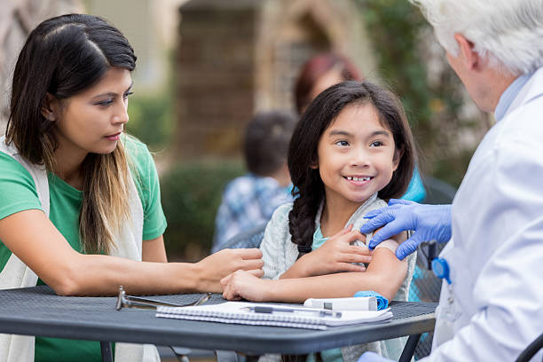 小さな女の子は、無料のクリニックで予防接種を受けた後に笑顔 - little girls vaccination child caucasian ストックフォトと画像