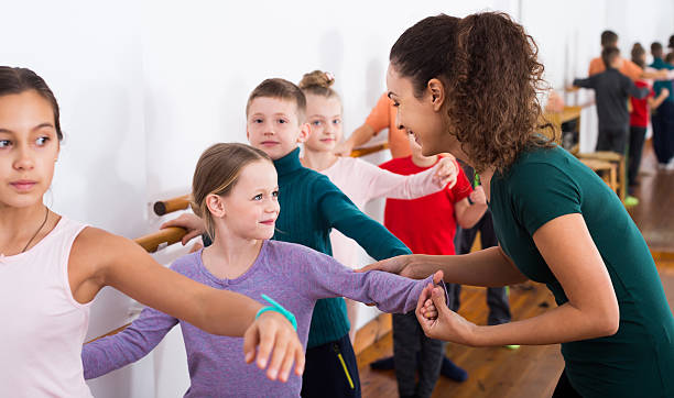 Group of children practicing at the ballet barre Group of smiling european children practicing at the ballet barre dance teacher kids stock pictures, royalty-free photos & images