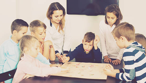 istock Children making move on pre-marked surface of board game 637275958