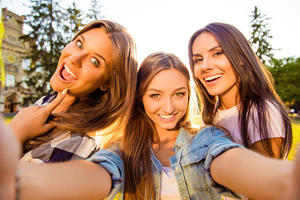 istock three attractive  girlfriends with toothy smile making selfie photo 637276090