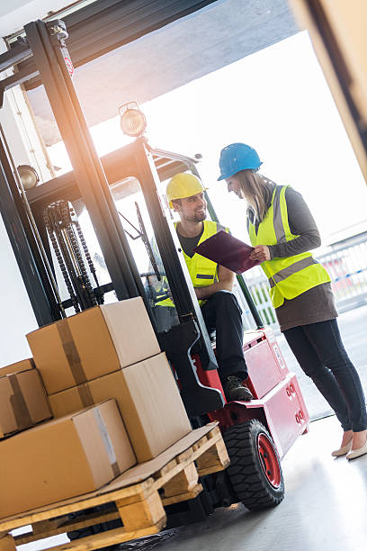 istock Forklift driver talking to a manager in the warehouse 637277104