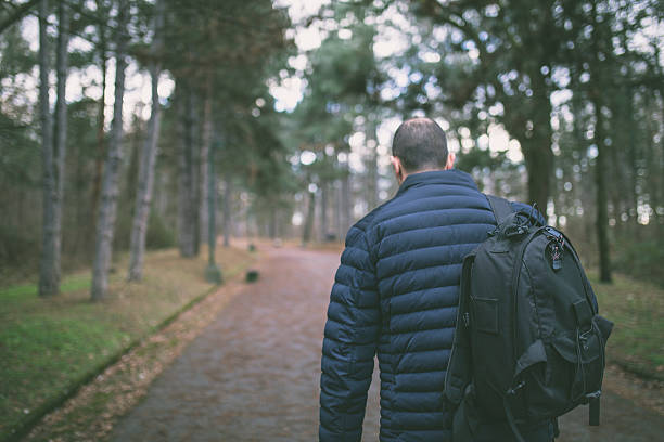 istock Man backpacker walking along a country road 637277238