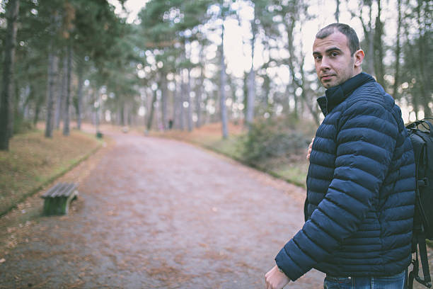 istock Man backpacker walking along a country road 637277504