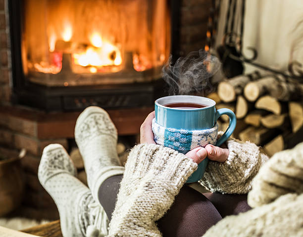 istock Relaxing near fireplace with a cup of hot drink. 637278698