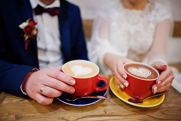 istock Newlyweds sitting on table at cafe with two cups 637278886