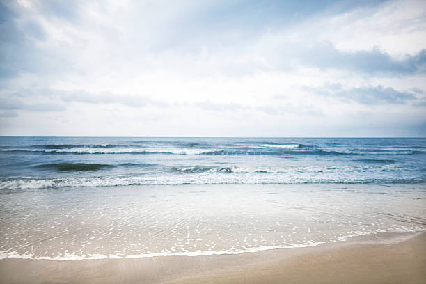 blick auf strand und wolken - vanishing point summer cloud sky stock-fotos und bilder