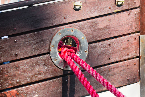Hawse of a ship's bow with two red ropes.