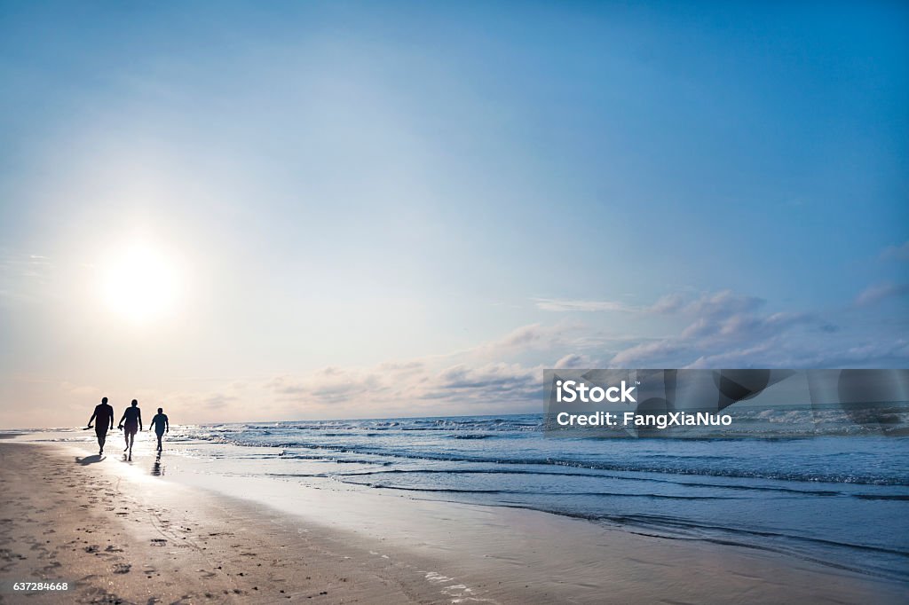 People walking on beach at sunrise People walking on beach at sunrise in Hilton Head, South Carolina Family Stock Photo